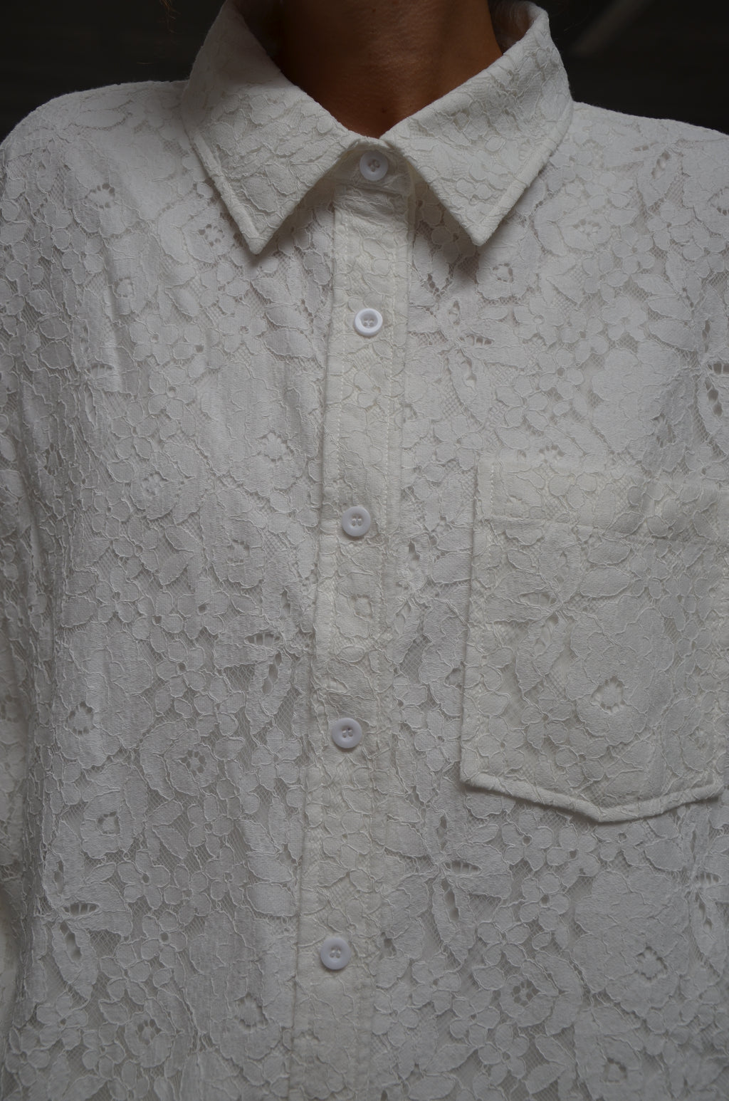 Close-up of a lace white shirt with floral patterns