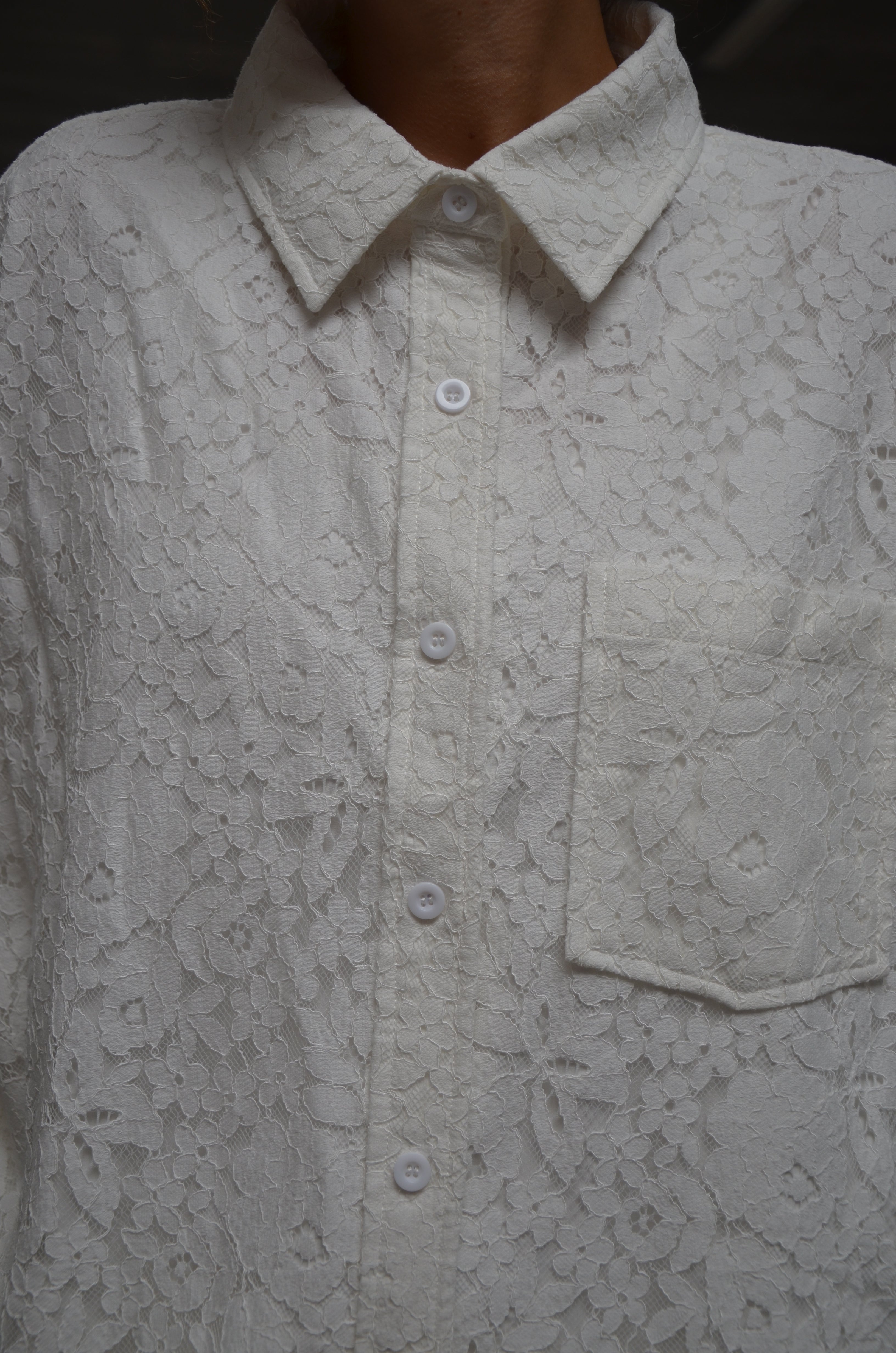 Close-up of a lace white shirt with floral patterns