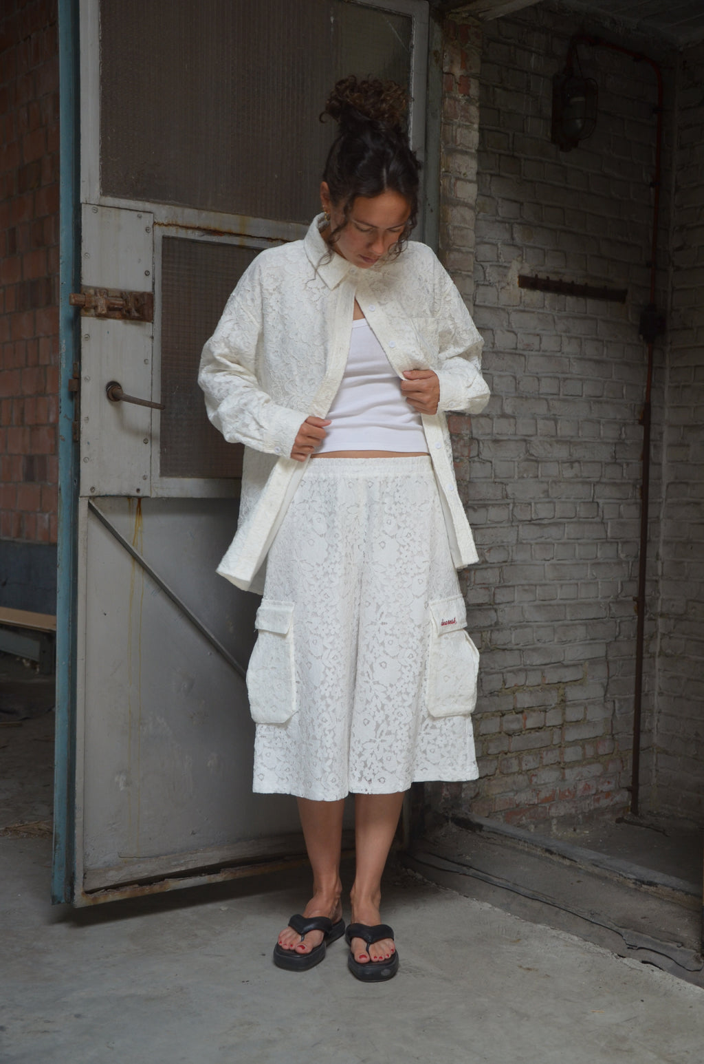 Person wearing a white shirt and matching shorts in a warehouse