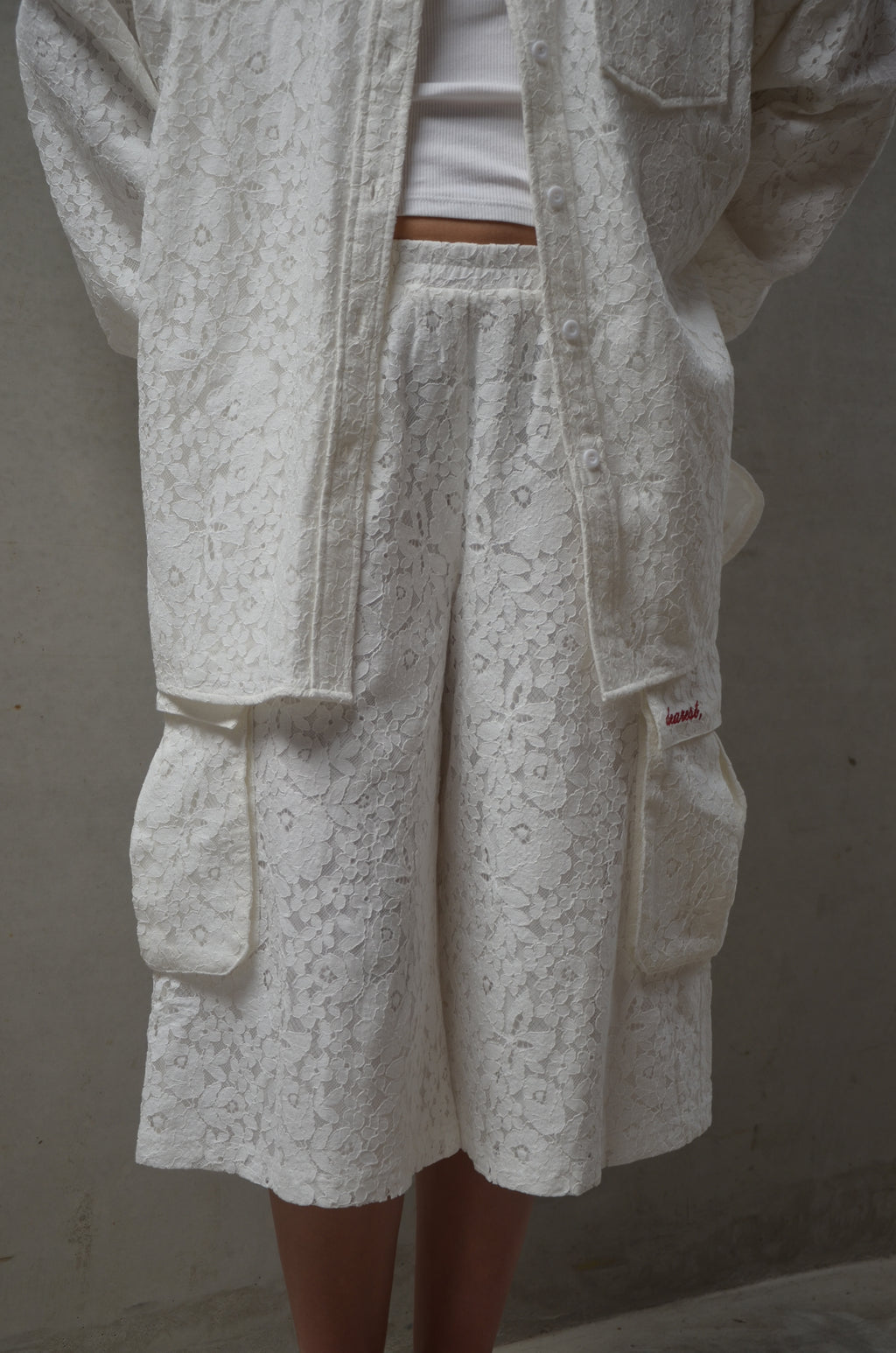 Close-up of white lace fabric garment on a plain background