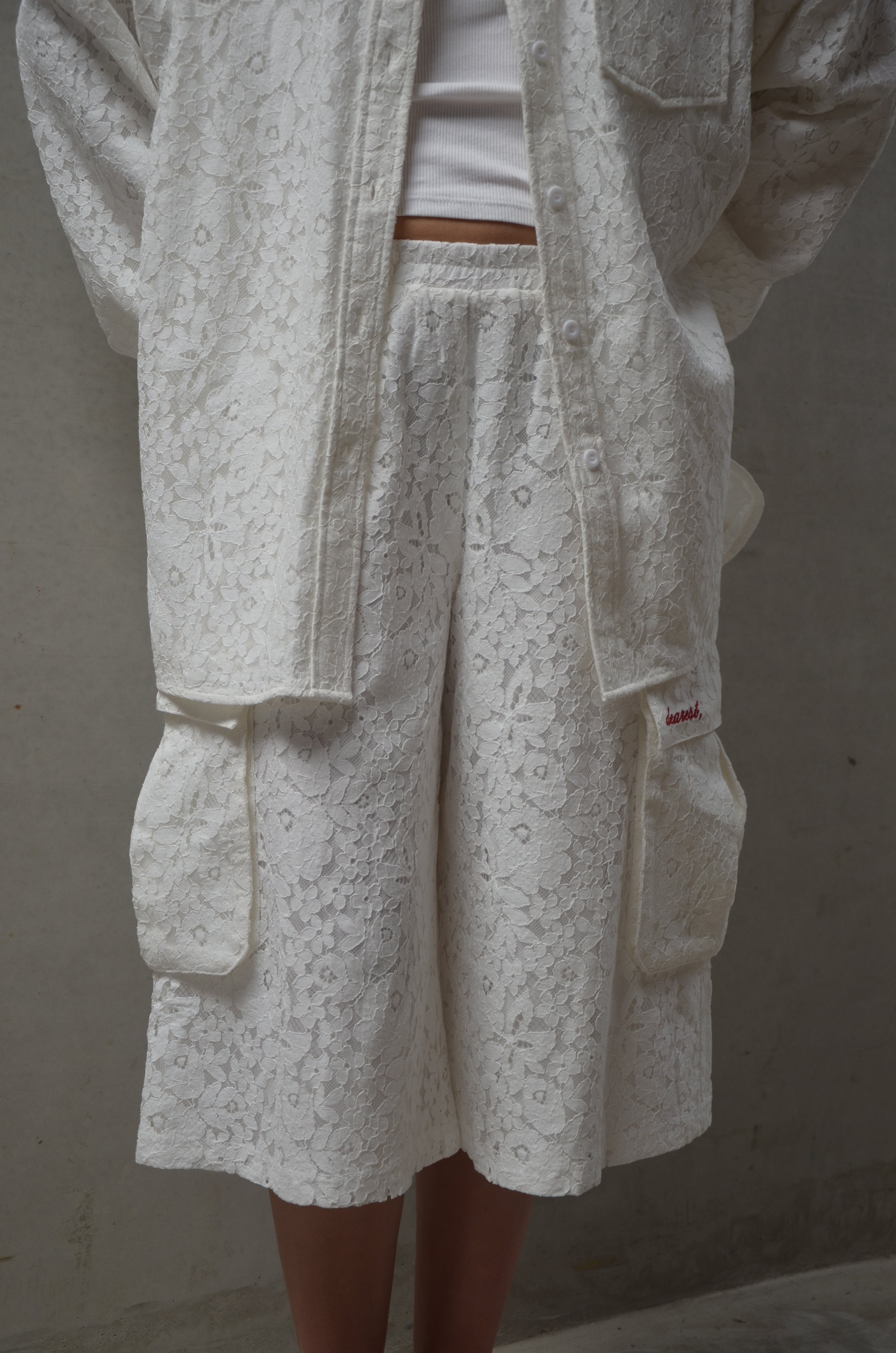 Close-up of white lace fabric garment on a plain background
